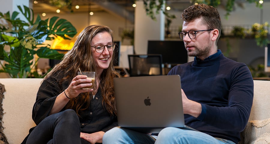 Twee deelnemers nemen de theorie door op één laptop tijdens Training HubSpot Marketing Software, om het certificaat te behalen.